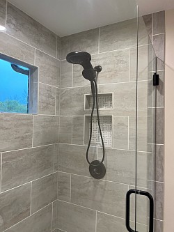 Talking about a huge shower head with a spray wand too! The 2 recessed niches are beautiful, as well.